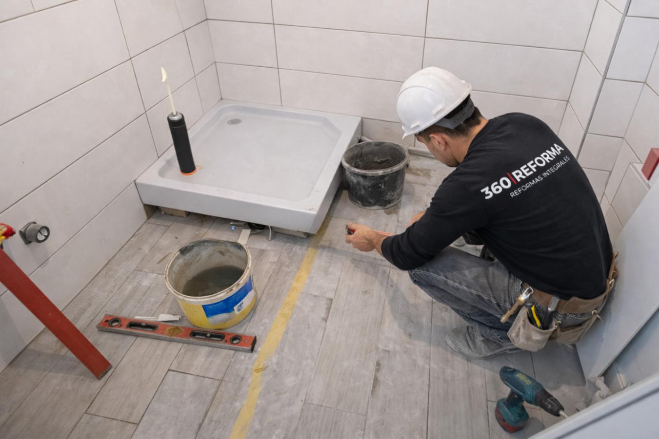Instalación de plato de ducha durante una reforma de baño en vivienda