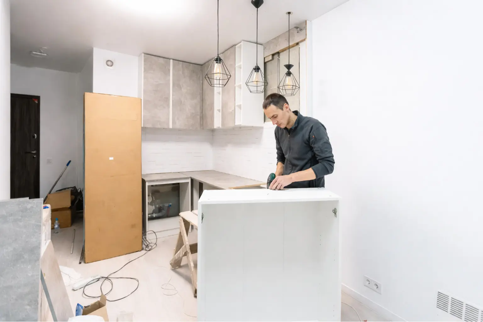 trabajador montando muebles en reforma de cocina moderna