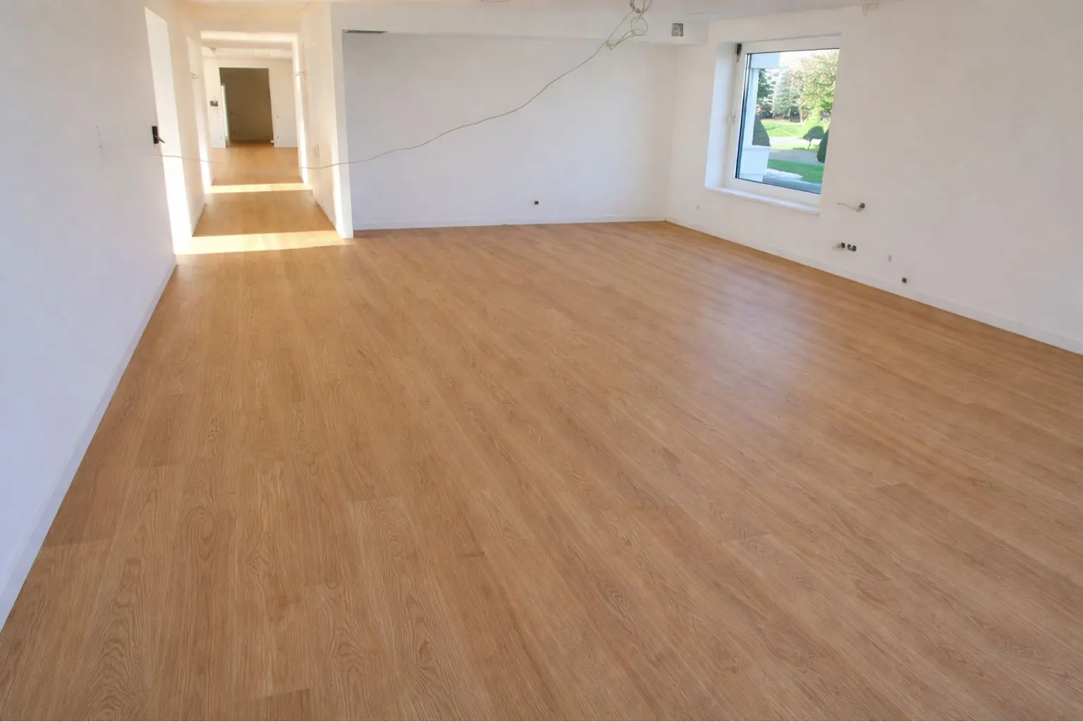 Suelo laminado efecto madera en salón tras reforma