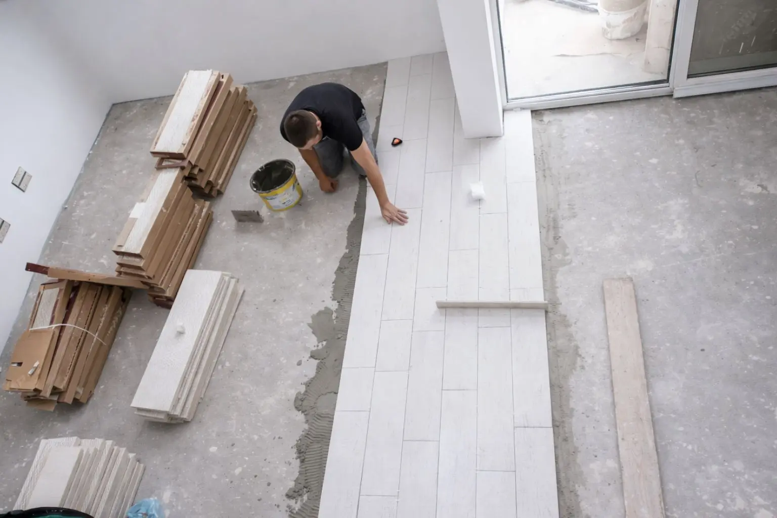 Instalación de suelo cerámico durante reforma de vivienda con colocación sobre mortero